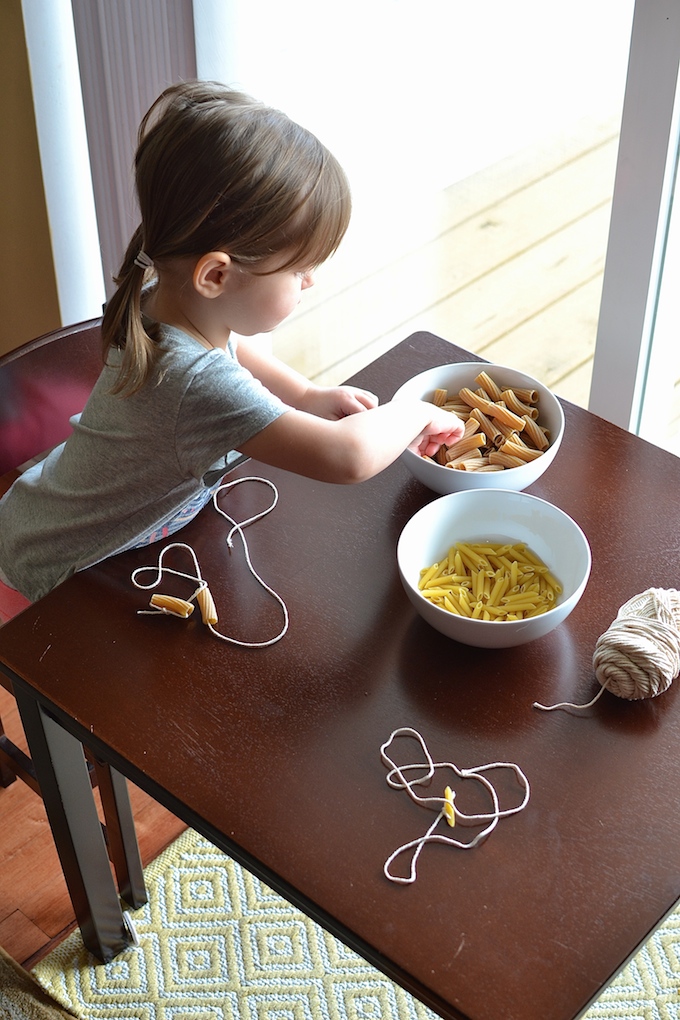 Threading with Noodles - Use pasta noodles like beads for threading in this activity to help strengthen children's fine motor skills! ~sweetpeasandabcs.com