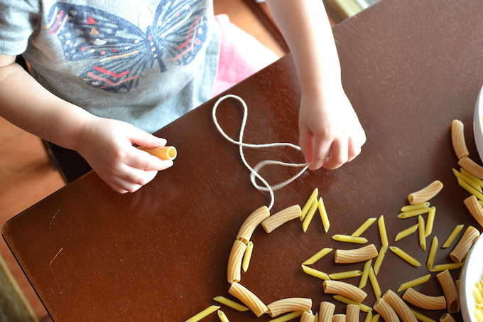 Threading with Noodles - Use pasta noodles like beads for threading in this activity to help strengthen children's fine motor skills! ~sweetpeasandabcs.com