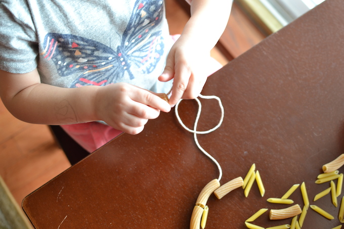 Threading with Noodles - Use pasta noodles like beads for threading in this activity to help strengthen children's fine motor skills! ~sweetpeasandabcs.com